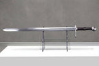 Épée Longue Voidstrike : épée longue en acier complète avec lame polie garde croisée poignée en cuir sombre et pommeau rond sur présentoir transparent sur fond de béton gris